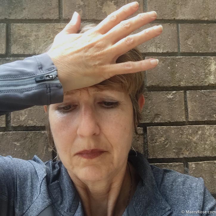 Woman holding her palm against her forehead